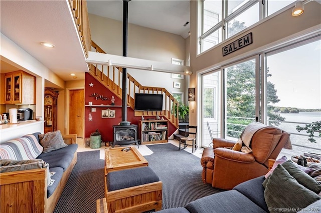 166 Old Colchester Rd, Salem, CT 06420 - living area with a wood stove, stairway, a towering ceiling, and carpet floors