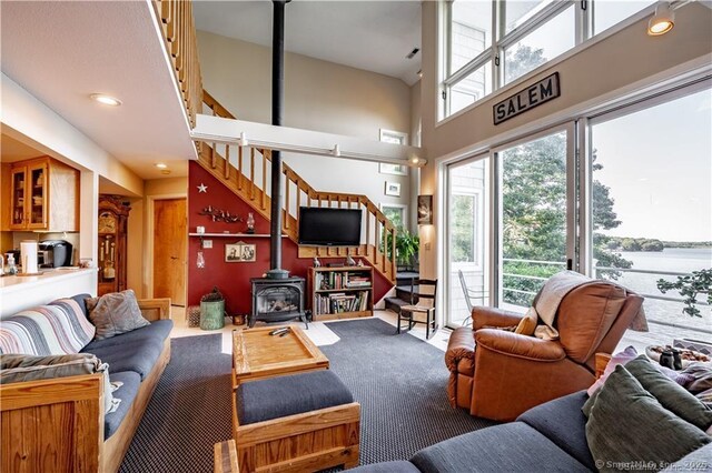 166 Old Colchester Rd, Salem, CT 06420 - living room featuring a wood stove, stairway, a towering ceiling, and carpet flooring