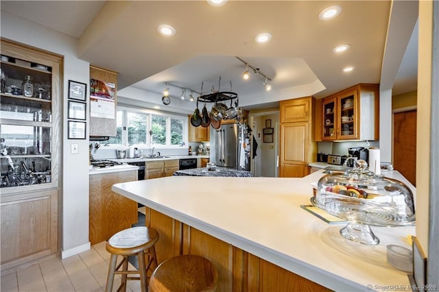 166 Old Colchester Rd, Salem, CT 06420 - kitchen with a tray ceiling, a peninsula, freestanding refrigerator, glass insert cabinets, and a breakfast bar