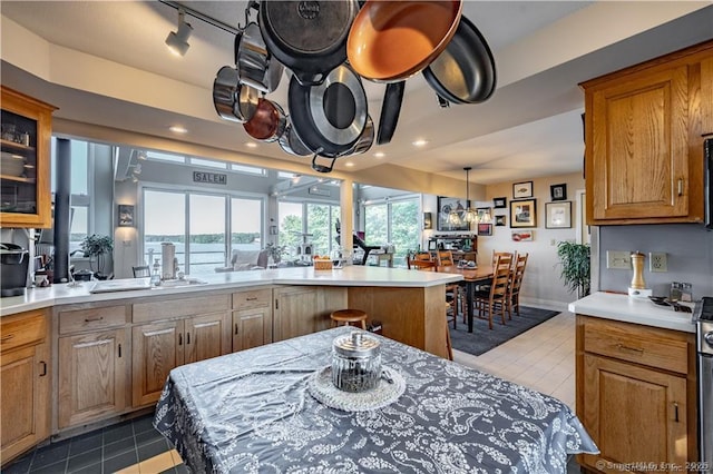 166 Old Colchester Rd, Salem, CT 06420 - kitchen featuring light countertops, glass insert cabinets, brown cabinets, recessed lighting, and tile patterned floors