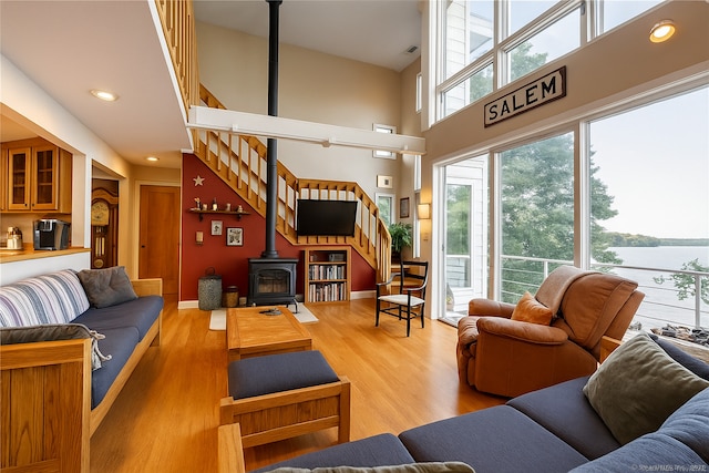 166 Old Colchester Rd, Salem, CT 06420 - living room with stairway, a wood stove, wood finished floors, a towering ceiling, and recessed lighting