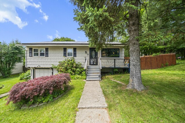 8 Cornfield Rd, Waterbury, CT 06704 - view of front facade with a front yard, a garage, and roof mounted solar panels