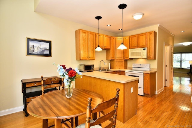 375 Allyn St Unit A4, Groton, CT 06355 - kitchen with white appliances, a peninsula, light wood-style floors, light countertops, and decorative light fixtures