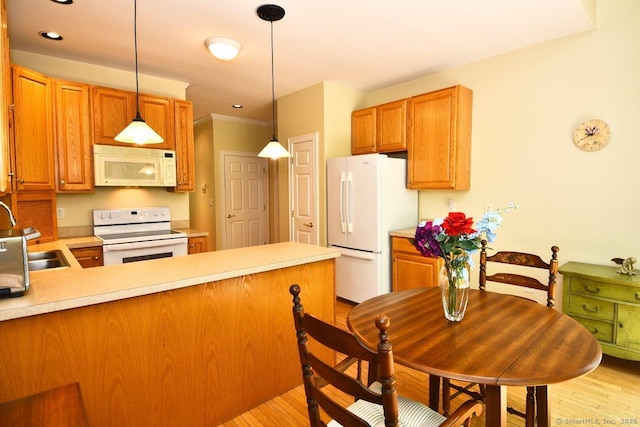375 Allyn St Unit A4, Groton, CT 06355 - kitchen with white appliances, light countertops, light wood finished floors, a peninsula, and pendant lighting