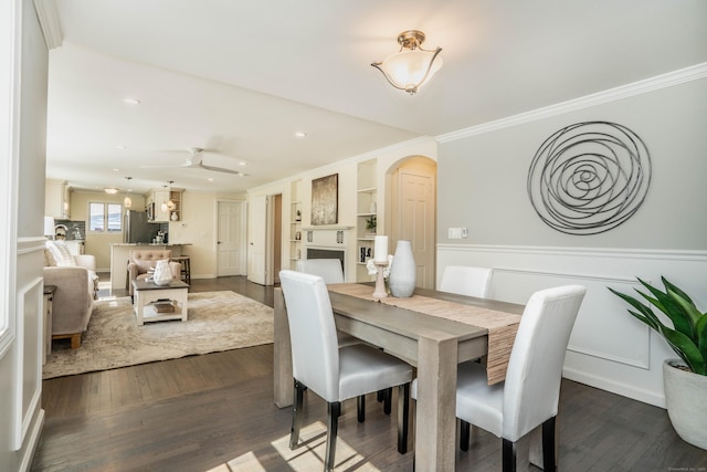 21 Walnut St, Newington, CT 06111 - dining area with arched walkways, dark wood-style flooring, ornamental molding, a wainscoted wall, and recessed lighting