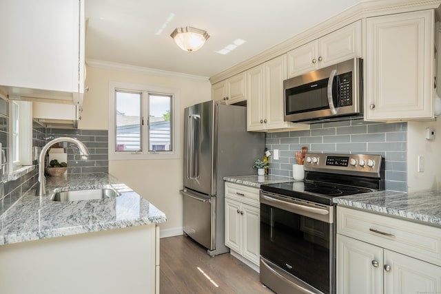 21 Walnut St, Newington, CT 06111 - kitchen with appliances with stainless steel finishes, cream cabinets, ornamental molding, wood finished floors, and backsplash