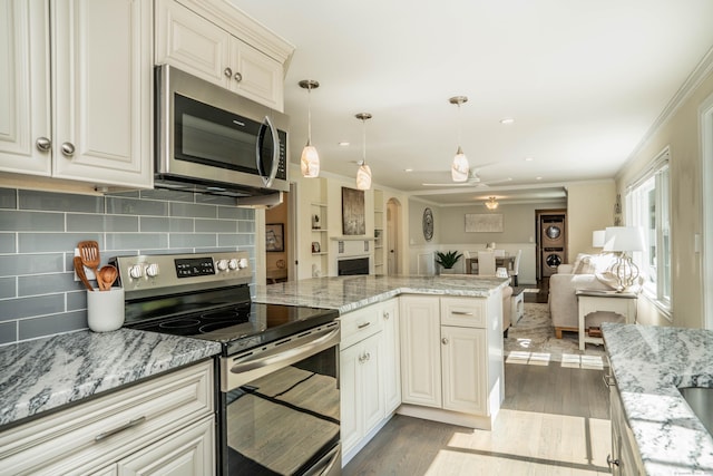 21 Walnut St, Newington, CT 06111 - kitchen featuring stainless steel appliances, ornamental molding, tasteful backsplash, a peninsula, and a ceiling fan