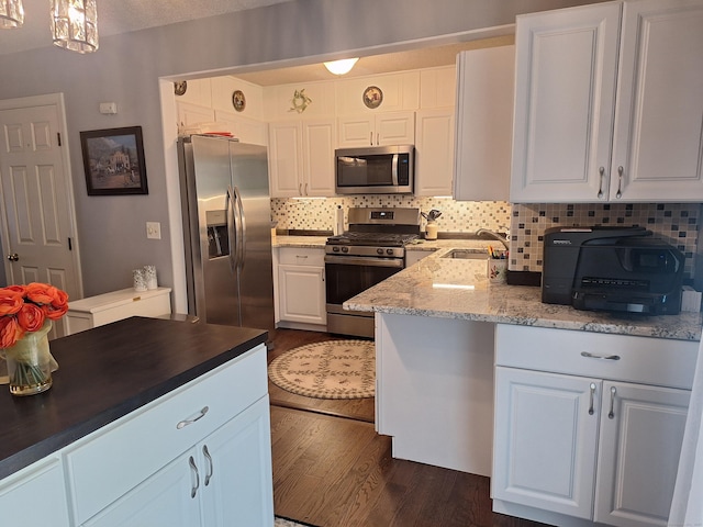 67 Fox Hollow Dr Unit 67, Windsor Locks, CT 06096 - kitchen featuring appliances with stainless steel finishes, dark wood finished floors, decorative backsplash, white cabinets, and dark stone countertops