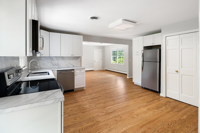 173 Russet Rd, Stamford, CT 06903 - kitchen featuring appliances with stainless steel finishes, a baseboard radiator, light wood-style flooring, white cabinetry, and decorative backsplash