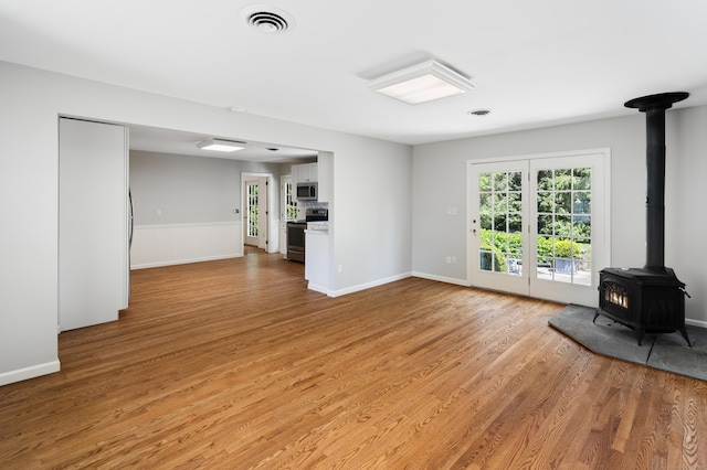 173 Russet Rd, Stamford, CT 06903 - unfurnished living room featuring a wood stove and light wood-style floors