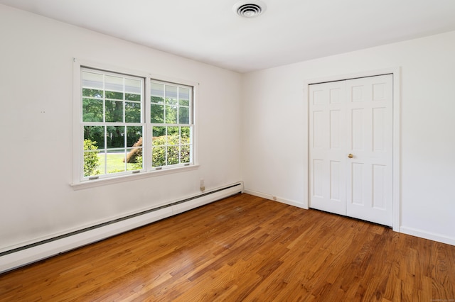 173 Russet Rd, Stamford, CT 06903 - unfurnished bedroom with a baseboard heating unit and light wood finished floors