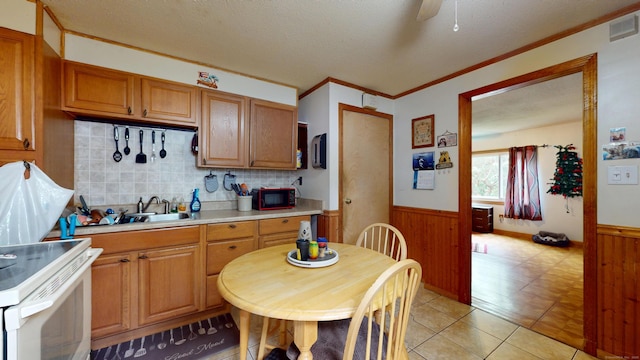 35 Cianci Rd, New Britain, CT 06053 - kitchen featuring white electric range oven, black microwave, light countertops, a wainscoted wall, and crown molding