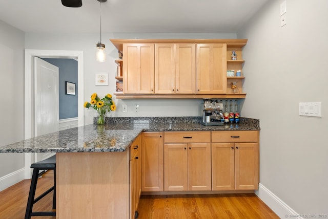 140 Griswold Dr, West Hartford, CT 06119 - kitchen featuring open shelves, light wood-type flooring, a breakfast bar area, and a peninsula