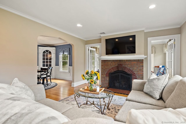 140 Griswold Dr, West Hartford, CT 06119 - living room featuring arched walkways, crown molding, wood finished floors, recessed lighting, and a brick fireplace