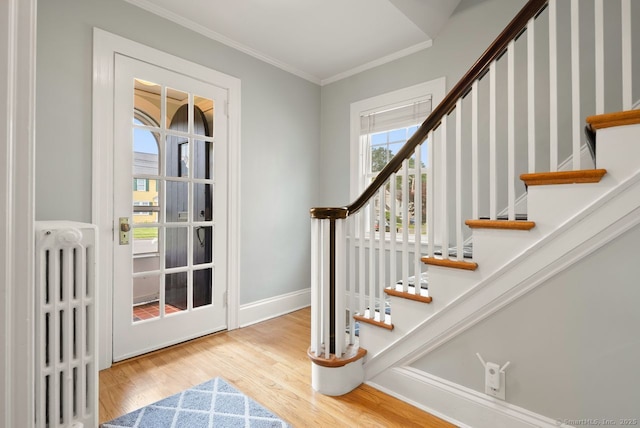 140 Griswold Dr, West Hartford, CT 06119 - foyer with radiator, wood finished floors, ornamental molding, and stairway