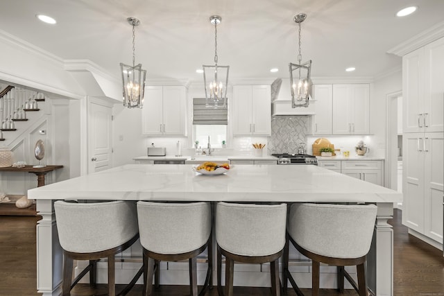 13 Myrtle St, Norwalk, CT 06855 - kitchen featuring custom exhaust hood, a kitchen island, white cabinetry, a kitchen breakfast bar, and tasteful backsplash