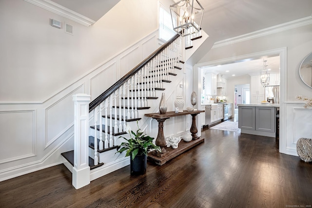 13 Myrtle St, Norwalk, CT 06855 - staircase featuring a decorative wall, a chandelier, ornamental molding, wood finished floors, and wainscoting