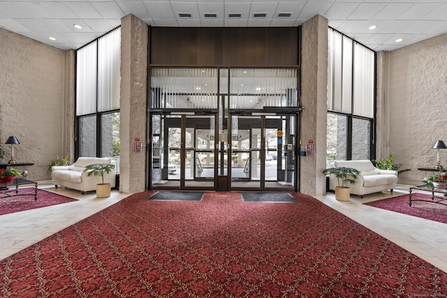 3200 Park Ave Unit 9B1, Bridgeport, CT 06604 - building lobby featuring floor to ceiling windows, a textured wall, a towering ceiling, and recessed lighting