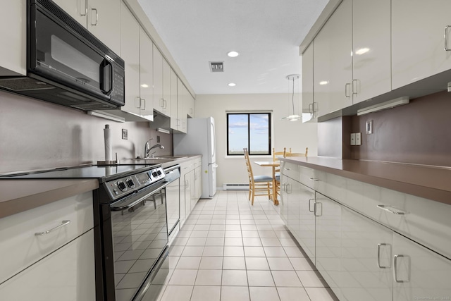 3200 Park Ave Unit 9B1, Bridgeport, CT 06604 - kitchen with electric stove, black microwave, white cabinets, light tile patterned floors, and stainless steel dishwasher