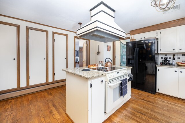 123 Silkey Rd, Granby, CT 06060 - kitchen with black fridge with ice dispenser, electric stove, white cabinets, decorative backsplash, and a center island