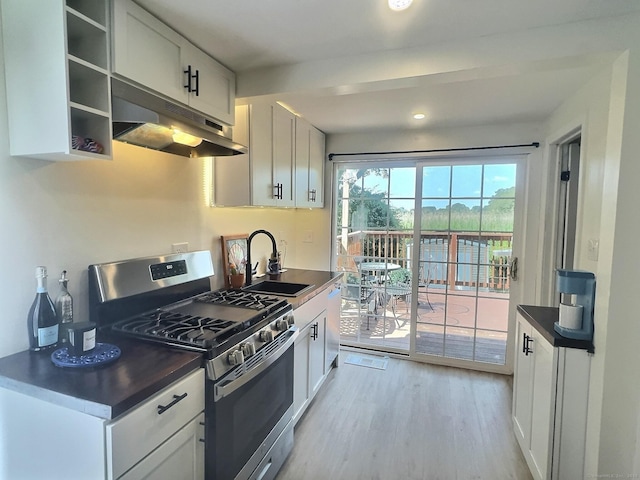102 Surf Ave, Milford, CT 06460 - kitchen featuring stainless steel gas range oven, under cabinet range hood, dark countertops, light wood-style floors, and white cabinets