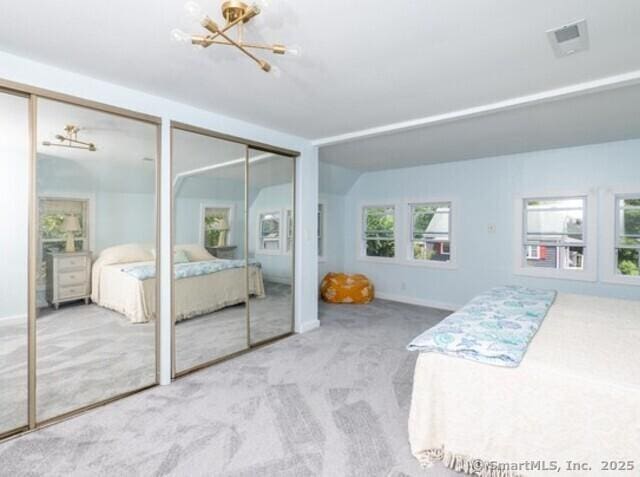 102 Surf Ave, Milford, CT 06460 - carpeted bedroom with multiple closets, multiple windows, and a chandelier
