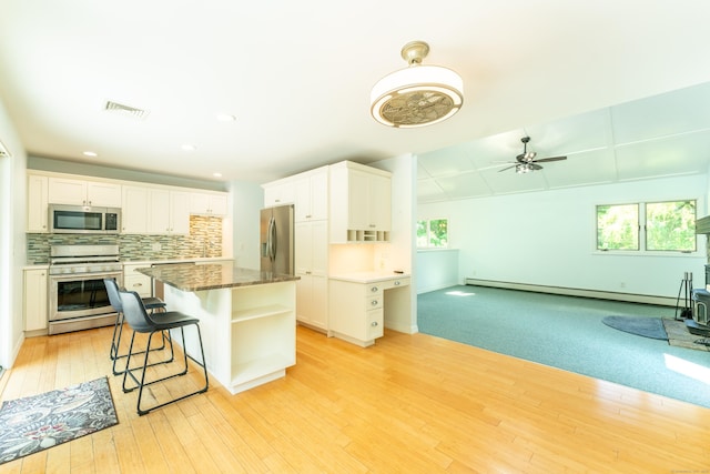 24 Newton St, Norwich, CT 06360 - kitchen featuring appliances with stainless steel finishes, a baseboard radiator, white cabinets, light wood-style floors, and recessed lighting