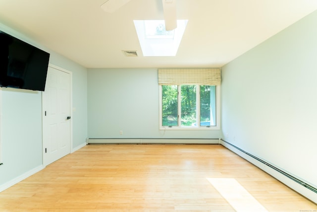 24 Newton St, Norwich, CT 06360 - empty room with a baseboard heating unit, light wood-style flooring, and a skylight