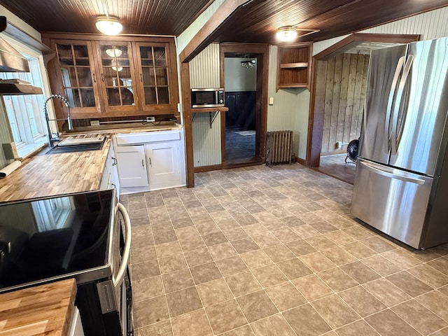 483 Providence Tpke, Hampton, CT 06247 - kitchen with stainless steel appliances, wood ceiling, wooden walls, wooden counters, and glass insert cabinets