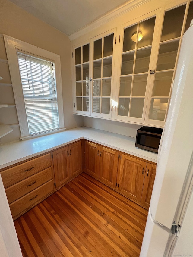 17 Maplewood Ave, West Hartford, CT 06119 - kitchen featuring stainless steel microwave, wood finished floors, light countertops, glass insert cabinets, and brown cabinets