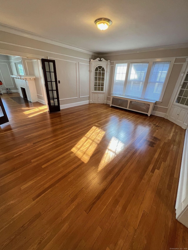17 Maplewood Ave, West Hartford, CT 06119 - unfurnished living room featuring a decorative wall, radiator, crown molding, a fireplace, and wood finished floors