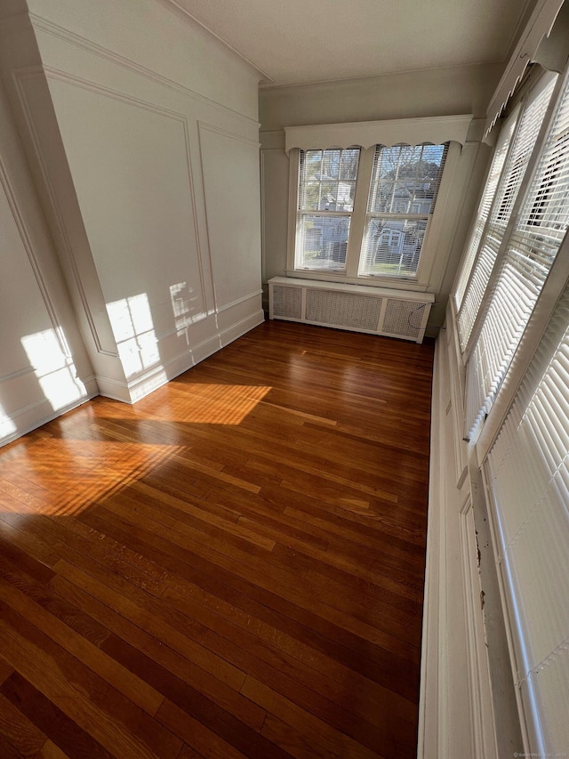 17 Maplewood Ave, West Hartford, CT 06119 - empty room featuring radiator, wood finished floors, and a decorative wall