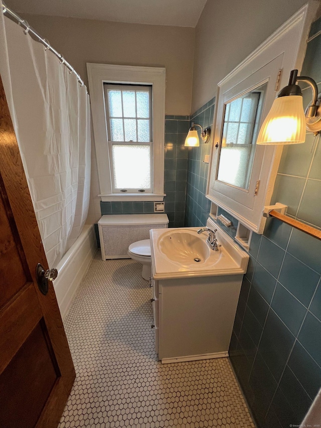 17 Maplewood Ave, West Hartford, CT 06119 - full bathroom with radiator, tile walls, vanity, shower / bath combo with shower curtain, and tile patterned floors