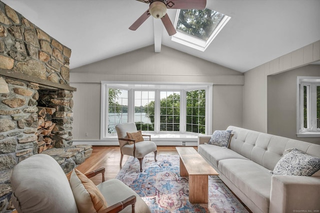 421 Hemlock Point Dr, Coventry, CT 06238 - living area featuring a ceiling fan, vaulted ceiling, a fireplace, baseboard heating, and a skylight