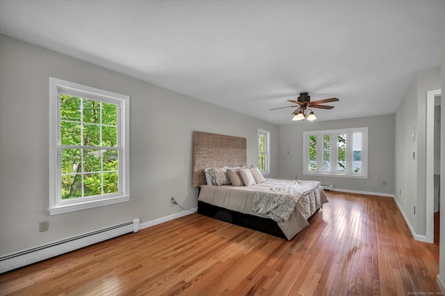 421 Hemlock Point Dr, Coventry, CT 06238 - bedroom featuring a baseboard heating unit, light wood-style flooring, and ceiling fan