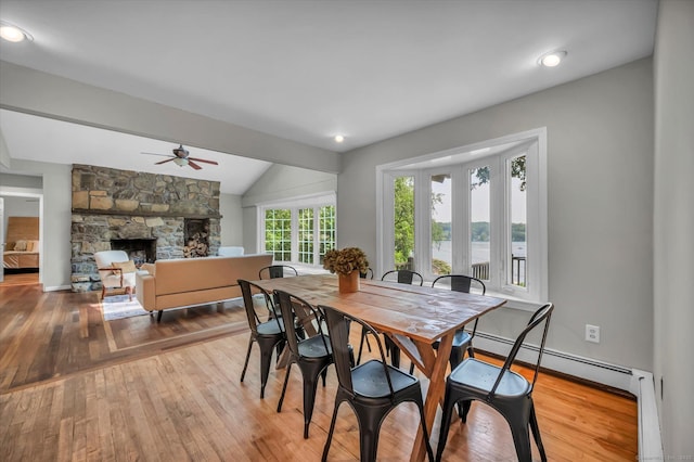 421 Hemlock Point Dr, Coventry, CT 06238 - dining room featuring a ceiling fan, wood-type flooring, vaulted ceiling, a stone fireplace, and baseboard heating