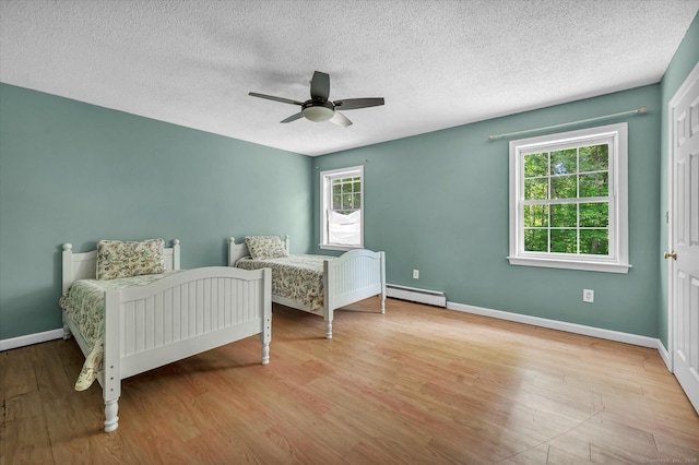 421 Hemlock Point Dr, Coventry, CT 06238 - bedroom featuring baseboard heating, multiple windows, wood finished floors, a textured ceiling, and a ceiling fan