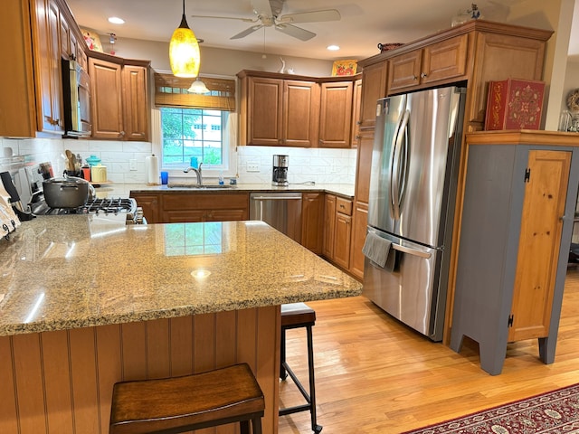 24 Alger Rd, East Haddam, CT 06423 - kitchen featuring appliances with stainless steel finishes, a peninsula, ceiling fan, light wood finished floors, and tasteful backsplash