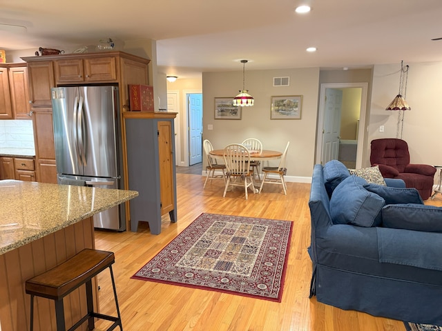 24 Alger Rd, East Haddam, CT 06423 - kitchen with freestanding refrigerator, light wood-style flooring, open floor plan, recessed lighting, and a breakfast bar area