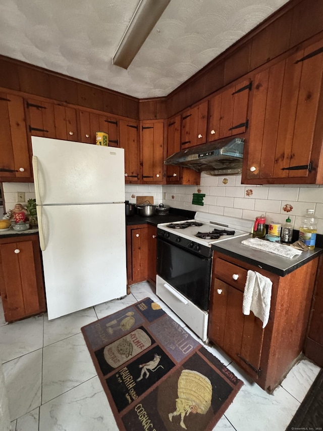 478 E Main St, Norwich, CT 06360 - kitchen featuring freestanding refrigerator, gas stove, under cabinet range hood, dark countertops, and tasteful backsplash