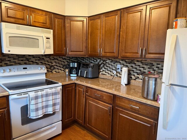 333 Vincellette St Unit 109, Bridgeport, CT 06606 - kitchen featuring white appliances, decorative backsplash, and brown cabinets