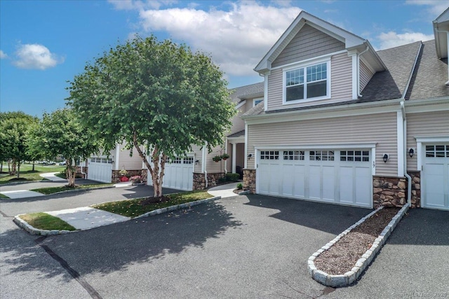 17 Brookside Ct Unit 17, Newtown, CT 06470 - view of front of property with stone siding, driveway, a shingled roof, and an attached garage
