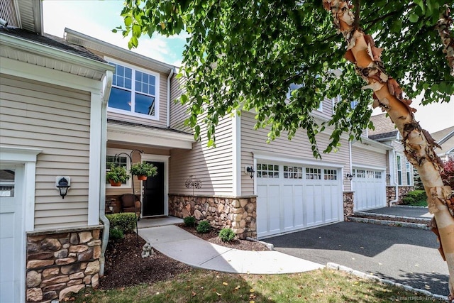 17 Brookside Ct Unit 17, Newtown, CT 06470 - view of front of property featuring stone siding, a garage, and driveway