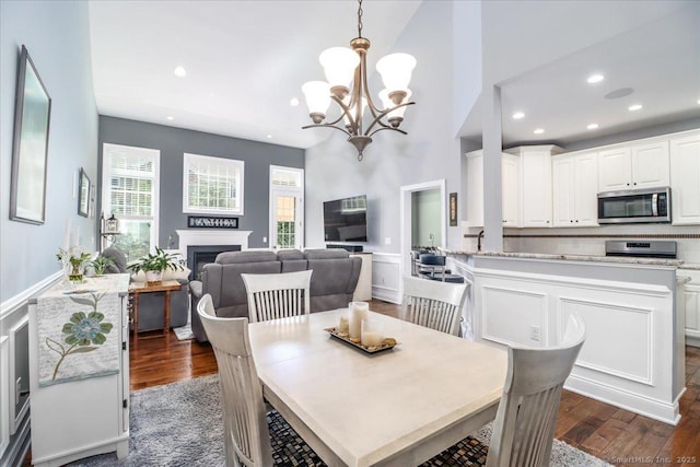 17 Brookside Ct Unit 17, Newtown, CT 06470 - dining room with recessed lighting, a fireplace, dark wood-style floors, a chandelier, and a towering ceiling
