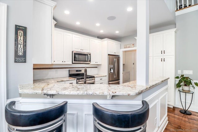 17 Brookside Ct Unit 17, Newtown, CT 06470 - kitchen with stainless steel appliances, recessed lighting, light stone counters, a peninsula, and a breakfast bar