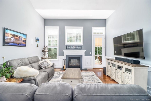 17 Brookside Ct Unit 17, Newtown, CT 06470 - living room featuring wood finished floors, plenty of natural light, a fireplace with flush hearth, and a wainscoted wall