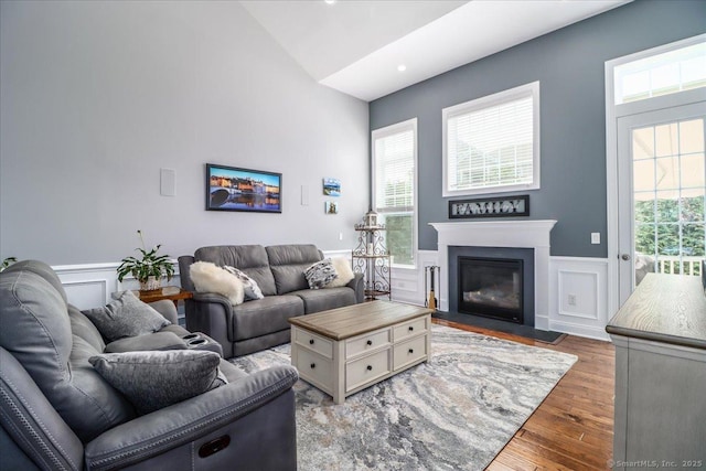 17 Brookside Ct Unit 17, Newtown, CT 06470 - living room featuring wainscoting, wood finished floors, a decorative wall, a fireplace with flush hearth, and plenty of natural light