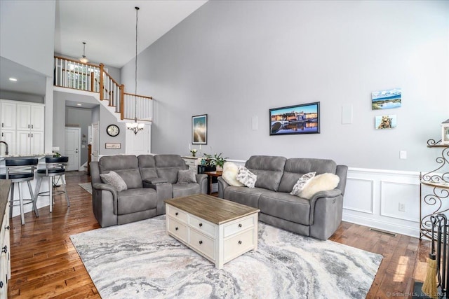 17 Brookside Ct Unit 17, Newtown, CT 06470 - living room with high vaulted ceiling, wood finished floors, wainscoting, and a decorative wall