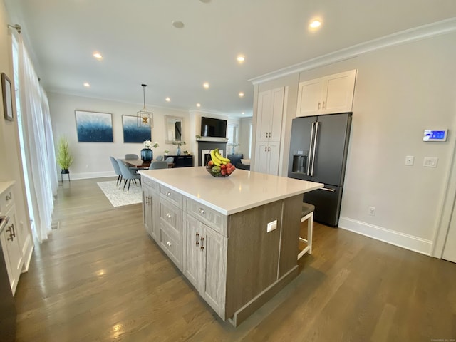 159 Colonial Rd Unit 5, Stamford, CT 06906 - kitchen featuring high quality fridge, a kitchen island, white cabinetry, light countertops, and ornamental molding