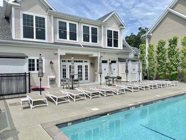 159 Colonial Rd Unit 5, Stamford, CT 06906 - rear view of property featuring french doors, a patio, a community pool, and a shingled roof